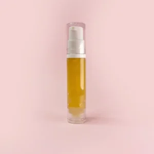 زجاجة مدمجة وأنيقة لعطر silky touch mini بحجم 10ml للتنقل، تظهر بسائل عطري ذهبي شفاف بداخلها، ومزودة برأس بخاخ أبيض وغطاء شفاف، موضوعة على خلفية وردية ناعمة.